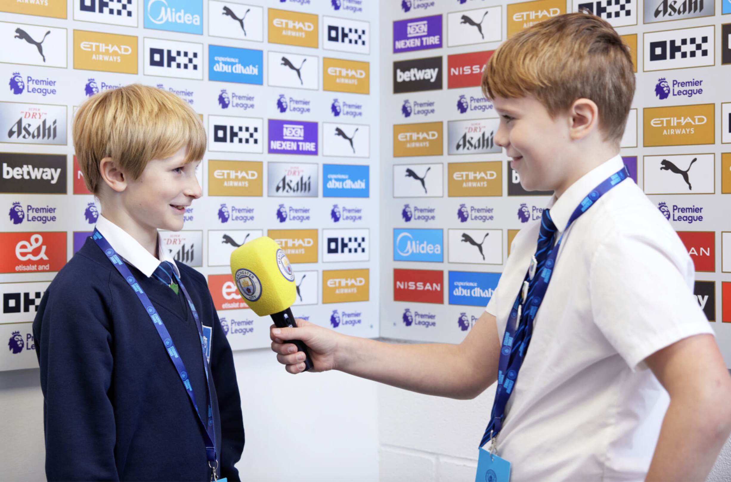 Students in Manchester City FC press room during educational tour